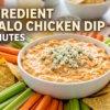 A white bowl filled with creamy orange buffalo chicken dip topped with blue cheese crumbles, surrounded by tortilla chips, celery sticks, and carrots on a wooden platter with bold text reading "3-Ingredient Buffalo Chicken Dip in 5 Minutes".